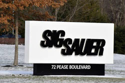 This Thursday, Jan. 14, 2016, file photo shows the sign at the entrance to the headquarters of Sig Sauer, a gun manufacturer based in Newington, N.H. Three former executives of German gun-maker Sig Sauer have gone on trial in Germany on suspicion of illegally selling firearms to Colombia by funneling them through a U.S. sister company.