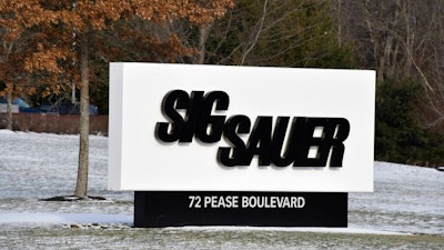 This Thursday, Jan. 14, 2016, file photo shows the sign at the entrance to the headquarters of Sig Sauer, a gun manufacturer based in Newington, N.H. Three former executives of German gun-maker Sig Sauer have gone on trial in Germany on suspicion of illegally selling firearms to Colombia by funneling them through a U.S. sister company.