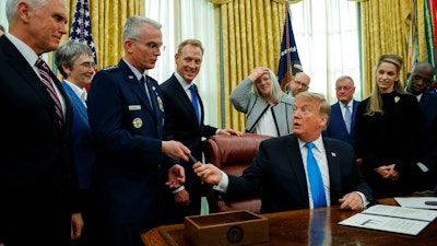President Donald Trump hands a pen to Air Force Gen. Paul Selva after signing 'Space Policy Directive 4' in the Oval Office of the White House, Tuesday, Feb. 19, 2019, in Washington.