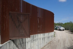 In this Aug. 11, 2017, file photo, a U.S. Customs and Border Patrol vehicle passes along a section of border levee wall in Hidalgo, Texas. The U.S. government is preparing to begin construction of more border walls and fencing in South Texas' Rio Grande Valley, likely on federally-owned land set aside as wildlife refuge property. Heavy construction equipment is supposed to arrive starting Monday. A photo posted by the nonprofit National Butterfly Center shows an excavator parked on its property.