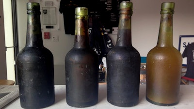 In this July 17, 2017 photo provided by Jamie Adams, four bottles recovered from the SS Oregon, a 133-year-old shipwreck, are shown at the Saint James Brewery in Holbrook, N.Y.