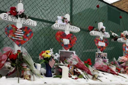 Crosses are placed for the victims of a mass shooting Sunday, Feb. 17, 2019, in Aurora, Ill., near Henry Pratt Co. manufacturing company where several were killed on Friday. Authorities say an initial background check five years ago failed to flag an out-of-state felony conviction that would have prevented a man from buying the gun he used in the mass shooting.