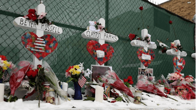 Crosses are placed for the victims of a mass shooting Sunday, Feb. 17, 2019, in Aurora, Ill., near Henry Pratt Co. manufacturing company where several were killed on Friday. Authorities say an initial background check five years ago failed to flag an out-of-state felony conviction that would have prevented a man from buying the gun he used in the mass shooting.