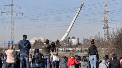 People watching the fall of a chimney during the blasting of a former coal-fired power station in Dortmund, Germany, Sunday, Feb. 17, 2019.
