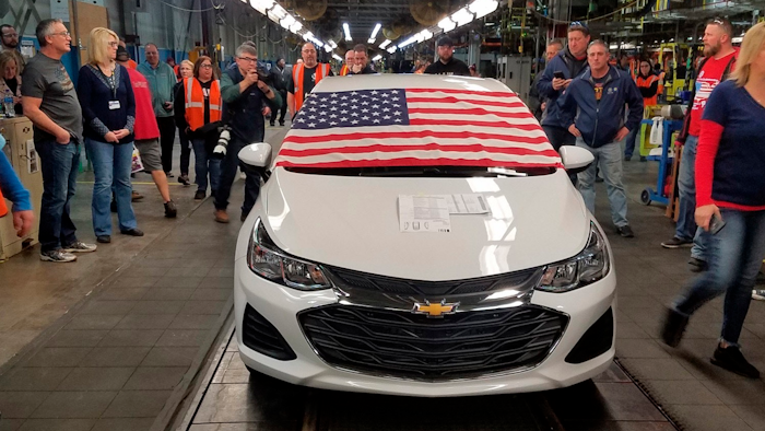 An American flag drapes the hood of the last Chevrolet Cruze as it comes off the assembly line at a General Motors plant where 1,700 hourly positions are being eliminated perhaps for good, on Wednesday, March 6, 2019, in Lordstown, Ohio. The factory near Youngstown is the first of five North American auto plants that GM plans to shut down by next year.