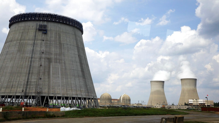 In this June 13, 2014, file photo, a new cooling tower for a nuclear power plant reactor that's under construction stands near the two operating reactors at Plant Vogtle power plant in Waynesboro, Ga. Energy Secretary Rick Perry announced Friday, March 22, 2019, that the Trump administration has finalized $3.7 billion in new loan guarantees to support completion of the first new U.S. commercial nuclear reactors in a generation, calling the expansion of nuclear energy 'the real' Green New Deal.