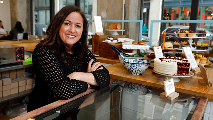 In this Wednesday, Feb. 6, 2019 photo, Dawn Casale, founder of One Girl Cookies, poses for photos in her shop in the Dumbo neighborhood of the Brooklyn borough of New York. Mayor Bill de Blasio wants New York to become the first place in the 50 states to make private businesses provide time off with pay. Employees at Casale's bakery get paid time off after five years, or if they're managers; others can arrange unpaid vacation, she said. 'I would love to be able to provide vacation time to my employees ... but the reality of it is not whether or not we want to give it — it's whether we can give it,' said Casale.
