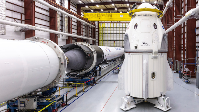In this Dec. 18, 2018 photo provided by SpaceX, SpaceX's Crew Dragon spacecraft and Falcon 9 rocket are positioned inside the company's hangar at Launch Complex 39A at NASA's Kennedy Space Center in Florida, ahead of the Demo-1 unmanned flight test. SpaceX rockets closer to human spaceflight with this weekend’s debut of a new capsule designed for astronauts. The six-day test flight will be real in every regard, beginning with a Florida liftoff Saturday, March 2, 2019, and a docking the next day with the International Space Station. But the Dragon capsule won’t carry humans, rather a test dummy in the same white SpaceX spacesuit that astronauts will wear.
