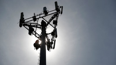 In this May 22, 2017, file photo Nick Blase with True North Management Services climbs down from a cellular phone town after performing maintenance as it is silhouetted against the sky in High Ridge, Mo. The 4G speeds, what we’re used to today, made possible many of the things we now take for granted on our phones, Instagram, cloud storage, Netflix. Also, for instance, that ride you got home from the bar.
