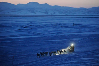 In this on March 11, 2012 file photo, Dallas Seavey pulls in to the checkpoint in Unalakleet, Alaska, during the Iditarod Trail Sled Dog Race. As of Friday, March 8, 2019, 51 mushers are traveling long stretches between remote village checkpoints with no other company but the dogs pulling their sleds. Their progress is monitored from several hotel rooms in Anchorage, Alaska, whose 24/7 occupants are the Iditarod’s electronic eyes and ears.