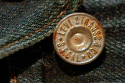 This March 12, 1997, file photo shows the top button on an approximately 100-year-old pair of jeans recently purchased by Levi Strauss & Co. for $25,000. The jeans were found in an abandoned mine, and are one of the two oldest-known pairs of Levi's in existence. The jeans were found in an abandoned mine. Levi Strauss & Co., which gave America its first pair of blue jeans, is going public for the second time on Thursday, March 21, 2019.