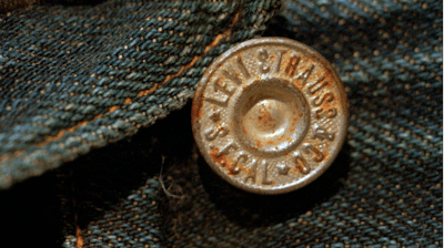 This March 12, 1997, file photo shows the top button on an approximately 100-year-old pair of jeans recently purchased by Levi Strauss & Co. for $25,000. The jeans were found in an abandoned mine, and are one of the two oldest-known pairs of Levi's in existence. The jeans were found in an abandoned mine. Levi Strauss & Co., which gave America its first pair of blue jeans, is going public for the second time on Thursday, March 21, 2019.