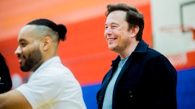 Tech billionaire Elon Musk smiles as he see how many students raise their hands when asked if they know what an engineer is while he and other Tesla officials talk with hundreds of Flint students on Friday, March 22, 2019 a Doyle-Ryder Elementary School in Flint, Mich. The Elon Musk Foundation announced in December it was giving about $424,000 to help provide laptops as the city recovers from a crisis with lead-tainted water.