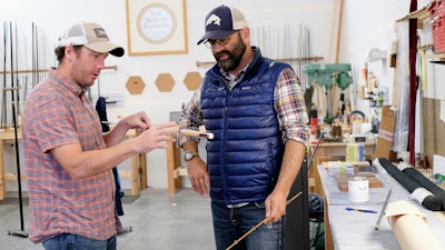 In this Sept. 15, 2017, photo co-owners of fishing rod manufacturer Tom Morgan Rodsmiths, Matt Barber, left, and Joel Doub inspect a rod during the build process at the company in Bozeman, Mont. When Barber and Doub bought the company two years ago, the plan was for previous owner Tom Morgan to stay with the business for five years to mentor them. But six months after the deal closed, Morgan died unexpectedly.