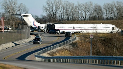 In this March 8, 2017, file photo, emergency personnel work at the scene after a plane carrying the Michigan men's basketball team slid off a runway during an aborted takeoff at Willow Run Airport, in Ypsilanti, Mich. Investigators said Thursday, March 7, 2019, the plane off a runway in 2017 after a jammed part prevented pilots from tilting the nose upward during takeoff.