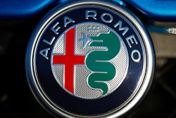 In this Sunday, Jan. 7, 2018, file photograph, the company logo shines on the grille of an unsold 2018 Stelvio at an Alfa Romeo dealership in Highlands Ranch, Colo. Fiat Chrysler is recalling more than 60,000 cars and SUVs worldwide because they can keep going on cruise control or accelerate even after a driver taps the brakes. The recall covers certain Alfa Romeo Giulia and Stelvio models from 2017 through 2019.