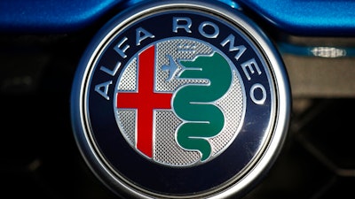 In this Sunday, Jan. 7, 2018, file photograph, the company logo shines on the grille of an unsold 2018 Stelvio at an Alfa Romeo dealership in Highlands Ranch, Colo. Fiat Chrysler is recalling more than 60,000 cars and SUVs worldwide because they can keep going on cruise control or accelerate even after a driver taps the brakes. The recall covers certain Alfa Romeo Giulia and Stelvio models from 2017 through 2019.