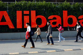In this March 17, 2014 file photo, people walk past a company logo at the Alibaba Group headquarters in Hangzhou, in eastern China's Zhejiang province. Office Depot and Alibaba.com are creating a co-branded online store to expand the reach of both companies with small and medium size businesses. The two companies announced the agreement Monday, March 4, 2019, as part of a broader array of services they are providing to small business. Over time, the companies intend to help U.S. small businesses sell their products to buyers around the world through Alibaba.com. It marks Alibaba.com’s first U.S. partnership with a major company.