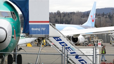 In this Monday, March 11, 2019 file photo, a Boeing 737 MAX 8 airplane being built for TUI Group sits parked in the background at right at Boeing Co.'s Renton Assembly Plant in Renton, Wash. The Transportation Department confirmed that its watchdog agency will examine how the FAA certified the Boeing 737 Max 8 aircraft, the now-grounded plane involved in two fatal accidents within five months. The FAA had stood by the safety of the plane up until last Wednesday, March 13, 2019 despite other countries grounding it.