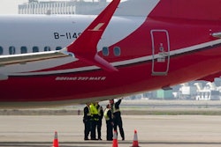 Ground crew chat near a Boeing 737 MAX 8 plane operated by Shanghai Airlines parked on tarmac at Hongqiao airport in Shanghai, China, Tuesday, March 12, 2019. U.S. aviation experts on Tuesday joined the investigation into the crash of an Ethiopian Airlines jetliner that killed 157 people, as a growing number of airlines grounded the new Boeing plane involved in the crash.