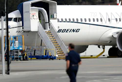 In this March 14, 2019, file photo a worker walks next to a Boeing 737 MAX 8 airplane parked at Boeing Field in Seattle. U.S. prosecutors are looking into the development of Boeing's 737 Max jets, a person briefed on the matter revealed Monday, the same day French aviation investigators concluded there were 'clear similarities' in the crash of an Ethiopian Airlines Max 8 last week and a Lion Air jet in October.
