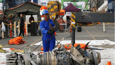 In this Nov. 4, 2018 file photo, officials move an engine recovered from the crashed Lion Air jet for further investigation in Jakarta, Indonesia. The brand new Boeing 737 MAX 8 jet plunged into the Java Sea just minutes after takeoff from Jakarta early on Oct. 29, killing all of its passengers on board. The FAA's oversight duties are coming under greater scrutiny after deadly crashes involving Boeing 737 Max jets owned by airlines in Ethiopia and Indonesia, killing a total of 346 people.