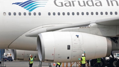 In this Sept. 28, 2015, file photo, workers clean a jetliner at GMF AeroAsia facility at Soekarno-Hatta International Airport in Jakarta, Indonesia. Indonesia's flag carrier is seeking the cancellation of a multibillion-dollar order for 49 Boeing 737 Max 8 jets, citing a loss of confidence in the model following two crashes in the space of a few months.