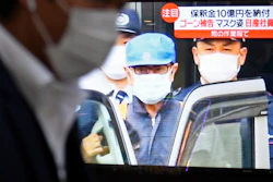 A man walks by a TV monitor which reports on former chairman of Nissan Motor Co., Carlos Ghosn, in Tokyo Wednesday, March 6, 2019. Disguised as a construction worker, Ghosn left a Tokyo detention center Wednesday after posting 1 billion yen ($8.9 million) bail.