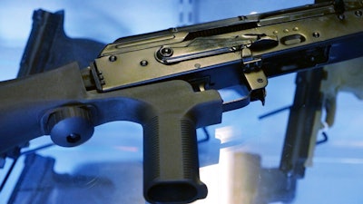 In this Oct. 4, 2017, file photo, a device called a 'bump stock' is attached to a semi-automatic rifle at the Gun Vault store and shooting range in South Jordan, Utah. In the days and weeks leading up to the ban on bump stocks that took effect Tuesday, March 26, 2019, tens of thousands of the devices were destroyed by owners or handed over to authorities.