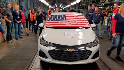 An American flag drapes the hood of the last Chevrolet Cruze as it comes off the assembly line at a General Motors plant where 1,700 hourly positions are being eliminated perhaps for good, on Wednesday, March 6, 2019, in Lordstown, Ohio. The factory near Youngstown is the first of five North American auto plants that GM plans to shut down by next year.