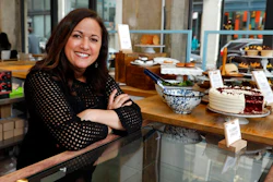 In this Wednesday, Feb. 6, 2019 photo, Dawn Casale, founder of One Girl Cookies, poses for photos in her shop in the Dumbo neighborhood of the Brooklyn borough of New York. Mayor Bill de Blasio wants New York to become the first place in the 50 states to make private businesses provide time off with pay. Employees at Casale's bakery get paid time off after five years, or if they're managers; others can arrange unpaid vacation, she said. 'I would love to be able to provide vacation time to my employees ... but the reality of it is not whether or not we want to give it — it's whether we can give it,' said Casale.