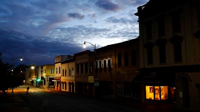 In this Oct. 28, 2017, file photo the storefront window of a portrait studio is lit up along a downtown street at dusk in Lumberton, N.C. Although small businesses vary widely in terms of size, industry and issues, they do appear to be generally united by a growing uneasiness about the economy. Several surveys and economic reports released in recent weeks show that company owners have more trust in their businesses than the national or local economy, and that they’re running their businesses more conservatively in response to uncertainty about overall business conditions.