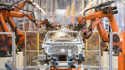 In this Saturday, March 9, 2019 file photo robots work on a VW Passat car at a plant of the car manufacturer Volkswagen in Emden, Germany.