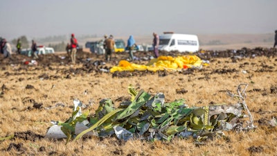 Parts of the plane wreckage with rescue workers at the crash site at Bishoftu, or Debre Zeit, outside Addis Ababa, Ethiopia, Monday, March 11, 2019, where Ethiopia Airlines Flight 302 crashed Sunday. Investigators are trying to determine the cause of a deadly crash Sunday involving a new aircraft model touted for its environmentally friendly engine that is used by many airlines worldwide.