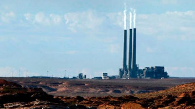 In this Sept. 4, 2011, file photo, smoke rises from the stacks of the main plant facility at the Navajo Generating Station, as seen from Lake Powell in Page, Ariz. The owners of one of the largest coal-fired power plants in the West say negotiations with a tribe to take over the plant have hit an impasse. A Navajo Nation energy company has been talking with owners of the Navajo Generating Station to buy the plant that's scheduled to shut down in December.