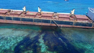 In this Feb. 26, 2019, photo taken by the Australian Maritime Safety Authority near Rennell Island in the Solomon Islands shows the “MV Solomon Trader” ship which ran aground Feb. 5. Australian officials say an environmental disaster is unfolding in the Solomon Islands after the ship ran aground and began leaking oil next to a UNESCO World Heritage site.