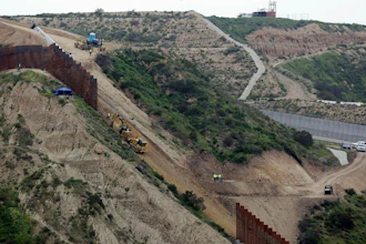 In this March 11, 2019 photo, construction crews replace a section of the primary wall separating San Diego, above right, and Tijuana, Mexico, below left, seen from Tijuana, Mexico. The Pentagon has sent a 20-page list of military construction projects to lawmakers who want to know which might be cut to pay for President Donald Trump’s wall along the border with Mexico. Democrats say the list shows that Trump is willing to cut needed defense spending and make the U.S. less secure, just to finance his wall. Trump has vetoed legislation aimed at blocking the cuts, and a veto override vote is set for next week.