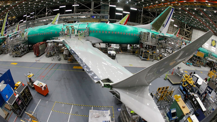 In this March 27, 2019, file photo taken with a fish-eye lens, a Boeing 737 MAX 8 airplane sits on the assembly line during a brief media tour in Boeing's 737 assembly facility in Renton, Wash. Boeing is cutting production of its grounded Max airliner this month to focus on fixing flight-control software and getting the planes back in the air. The company said Friday, April 5, that starting in mid-April it will cut production of the 737 Max from 52 to 42 planes per month.
