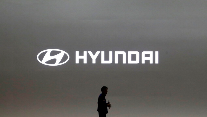 In this March 28, 2019, file photo a journalist passes by the logo of Hyundai Motor during a media preview of the Seoul Motor Show in Goyang, South Korea. Hyundai has found a new problem that can cause its car engines to fail or catch fire, issuing yet another recall to fix problems that have affected more than 6 million vehicles since 2015.