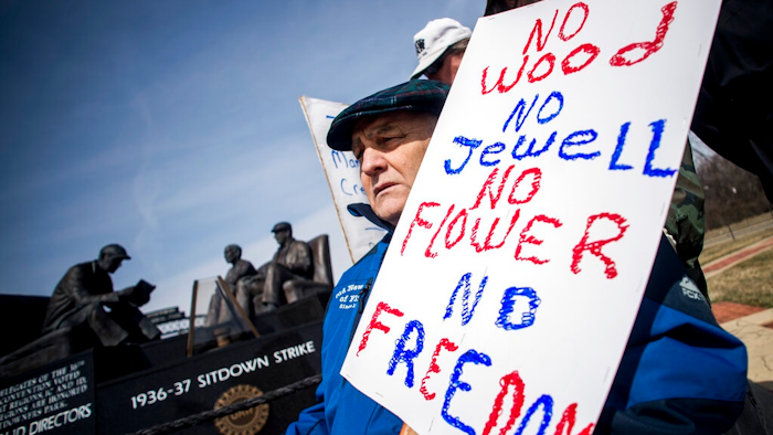 Genesee County Clerk-Register John Gleason protests alongside a dedicated handful United Auto Workers retirees during a protest against former UAW 1-C Director Norwood Jewell, Tuesday, April 2, 2019 at Sitdowners Memorial Park in Flint, Mich. Jewell is expected to enter a plea agreement Tuesday, on charges related to misuse of union workers' training funds. The retired UAW workers who protested are asking for all mentions of Jewell's name to be removed from the park.