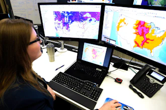 In this March 21, 2019 file photo, Whitney Flynn, a physical scientist at the National Water Center in Tuscaloosa, Ala., works on computer screens showing flood predictions and other information. An arsenal of new technology is being put to the test fighting floods this year as rivers inundate towns and farm fields across the central United States. Drones, supercomputers and sonar that scans deep under water are helping to maintain flood control projects, and predicting just where rivers will roar out of their banks.