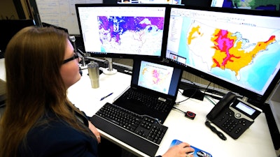 In this March 21, 2019 file photo, Whitney Flynn, a physical scientist at the National Water Center in Tuscaloosa, Ala., works on computer screens showing flood predictions and other information. An arsenal of new technology is being put to the test fighting floods this year as rivers inundate towns and farm fields across the central United States. Drones, supercomputers and sonar that scans deep under water are helping to maintain flood control projects, and predicting just where rivers will roar out of their banks.