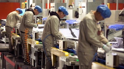 In this Friday, Feb. 24, 2017, file photo, factory workers assemble the cases of air conditioners on an assembly line at a factory in Jiaozhou, eastern China's Shandong Province. Two surveys show Chinese factory activity grew in April but below the previous month's pace amid a tariff battle with Washington.