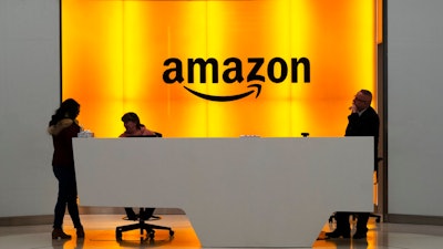 In this Feb. 14, 2019 file photo, people stand in the lobby for Amazon offices in New York. Amazon.com Inc. reports earns on Thursday, April 25.