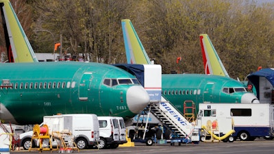 In this file photo Boeing 737 Max 8 jets, built for American Airlines, left, and Air Canada are parked at the airport adjacent to a Boeing production facility in Renton, Washington.