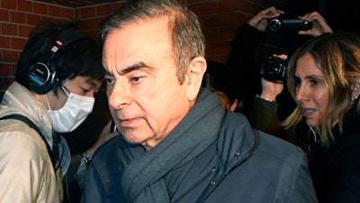 In this April 3, 2019, photo, former Nissan Chairman Carlos Ghosn, center, returns to his residence in Tokyo. Japanese prosecutors said Monday, April 22, 2019, they have indicted Nissan’s former chairman Ghosn with additional charges of breach of trust, with his alleged misconduct expanding outside Japan.