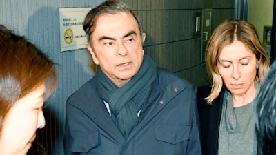 Former Nissan Chairman Carlos Ghosn, center, leaves his lawyer's office in Tokyo, Wednesday, April 3, 2019. Ghosn, facing financial misconduct charges in Japan, says he will hold a news conference on April 11.