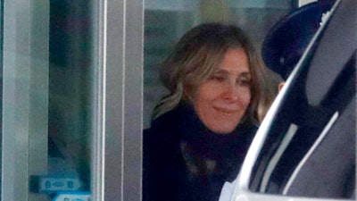 In this March 6, 2019, file photo, Carole Ghosn, wife of Nissan's former Chairman Carlos Ghosn, walks to a car waiting at the entrance of Tokyo Detention Center, where her husband is detained in Tokyo. Carole Ghosn will be questioned Thursday, April 11, 2019 by Japanese prosecutors in a Tokyo court.