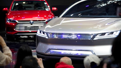 In this April 25, 2018, file photo, attendees take photos of the E-SEED electric concept car during a press conference by Chinese automaker BYD at the China Auto Show in Beijing. The 2019 Shanghai auto show highlights the global industry's race to transform electric cars into a profitable product Chinese drivers want to buy as Beijing winds down multibillion-dollar subsidies that made this country the biggest market for the technology.