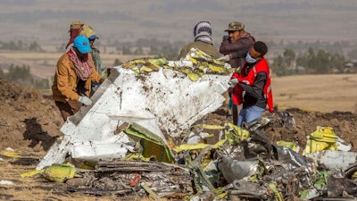 In this March 11, 2019, file photo, rescuers work at the scene of an Ethiopian Airlines flight crash near Bishoftu, Ethiopia. A published report says pilots of an Ethiopian airliner that crashed followed Boeing’s emergency steps for dealing with a sudden nose-down turn but couldn’t regain control.